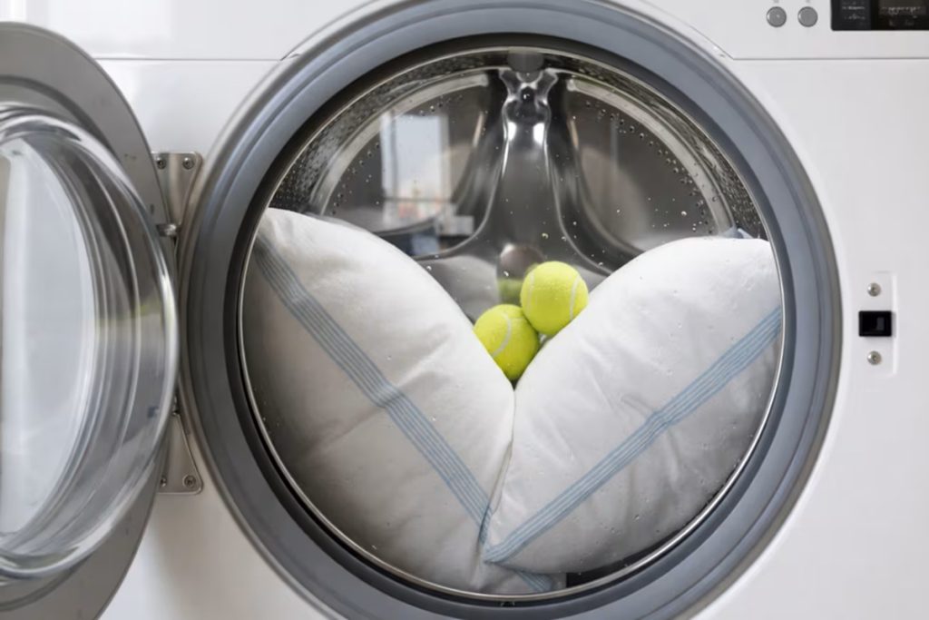 Colocar uma bola de ténis com almofadas na máquina de lavar roupa: para que serve e por que recomendam fazê-lo