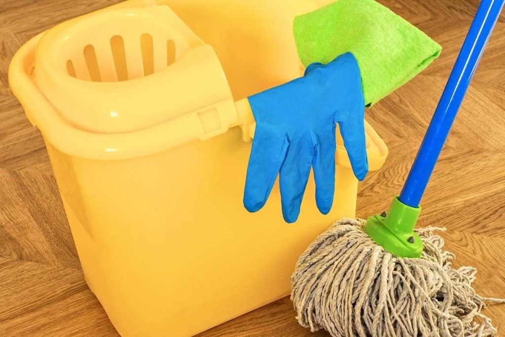 Piso de madeira limpo e brilhante com a mistura caseira no balde da esfregona: reflete a luz como no primeiro dia com a primeira passagem